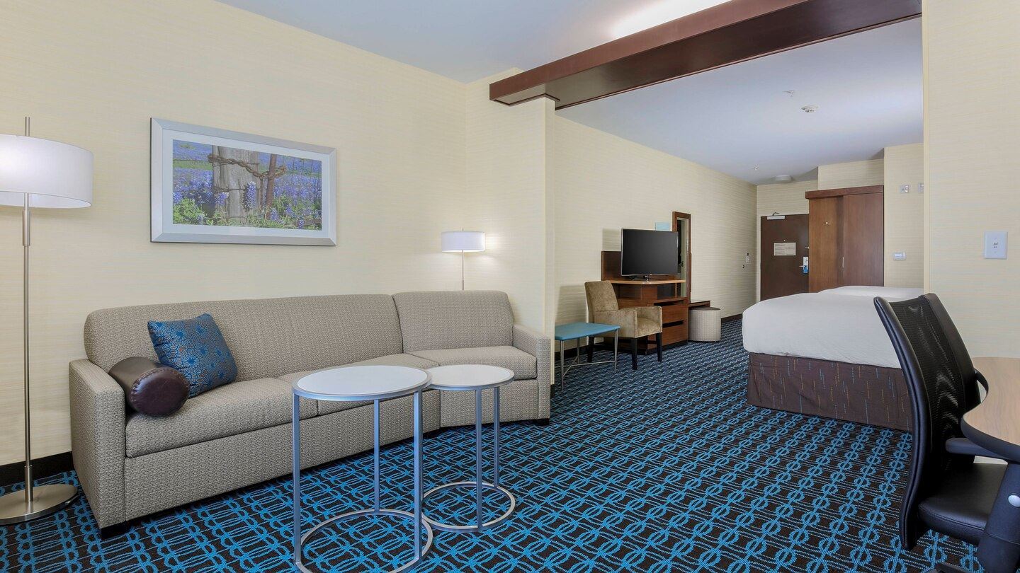 Queen suite with living area that has a couch and work desk