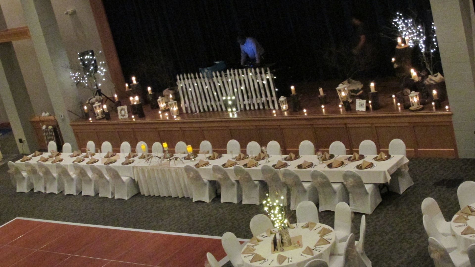 winter wedding reception view of the head table with white chairs and table cloth with beige napkins